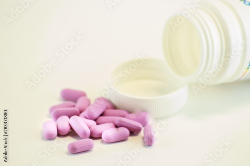 pills spilling out of pill bottle isolated on white