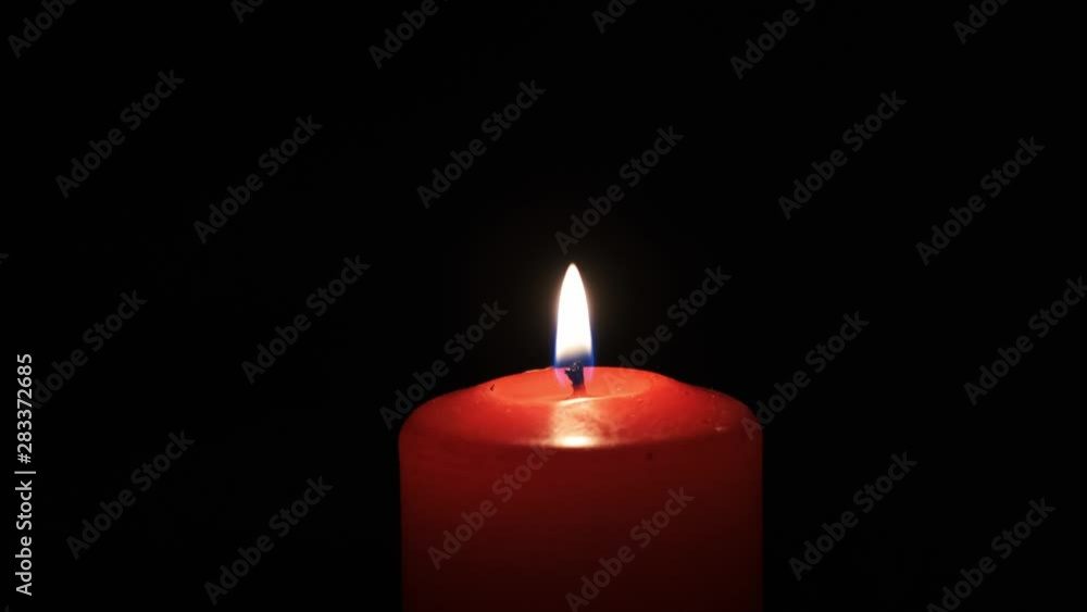 Burning red candle on black background. Burning red candle on black background.
