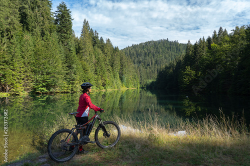 nice and ever young senior woman with her electric mountain bike at the Kinzig drinking Water reservoir in the northern Black Forest, Baden-Wuerttemberg, Germany