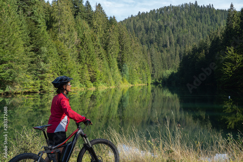 nice and ever young senior woman with her electric mountain bike at the Kinzig drinking Water reservoir in the northern Black Forest, Baden-Wuerttemberg, Germany