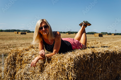 Fotografia Portrait of  beauty blonde caucasian woman lie on redneck of straw