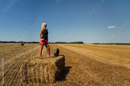 Portrait of  beauty blonde caucasian woman standing on redneck of straw with backpack photo
