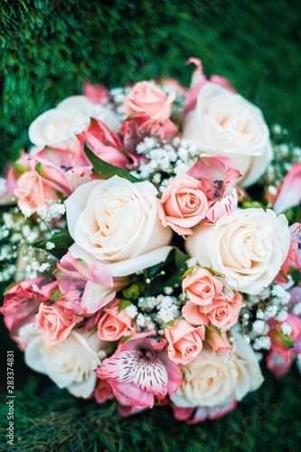 Close-up photo of wedding bouquet lying on green grass.