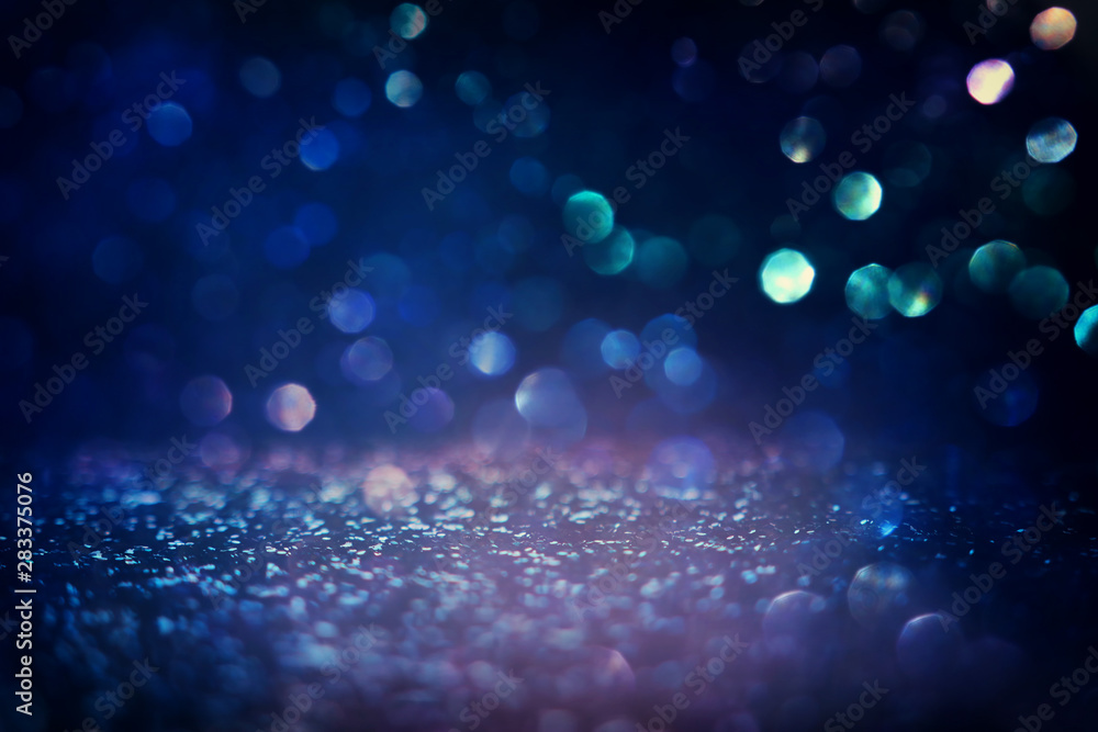 blackground of abstract glitter lights. blue, gold and black. de focused