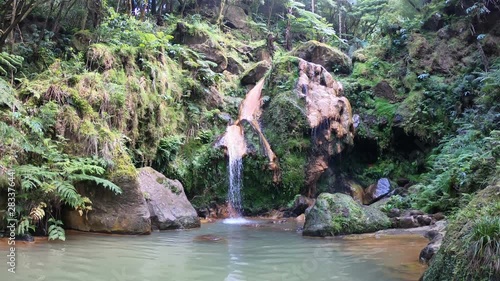 Small waterfall and lake in Caldeira Velha, popular, scenic nature preserve featuring lush vegetation, a waterfall on Sao Miguel Island, Azores, Portugal