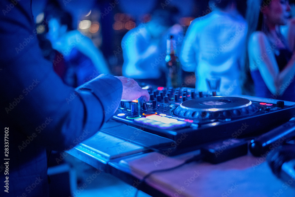 Dj mixing at party festival with crowd of people dancing in background. Dj mixing at party festival with crowd of people dancing in background.