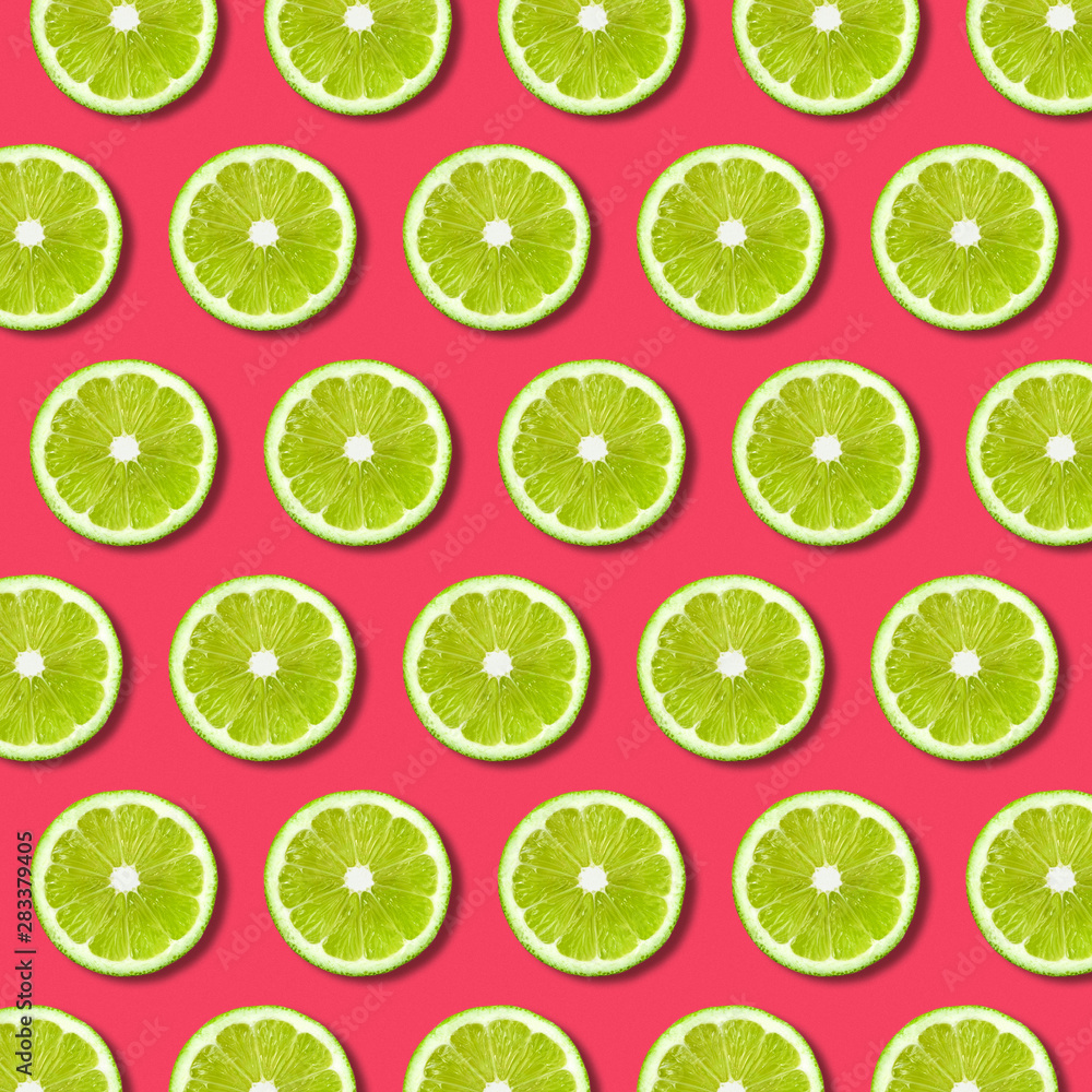 Vibrant fruit pop art background with green lime slices on red background. Minimal flat lay food pattern and texture 