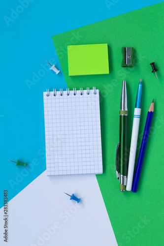 notebook and pencil isolated on white, blue and green background top view