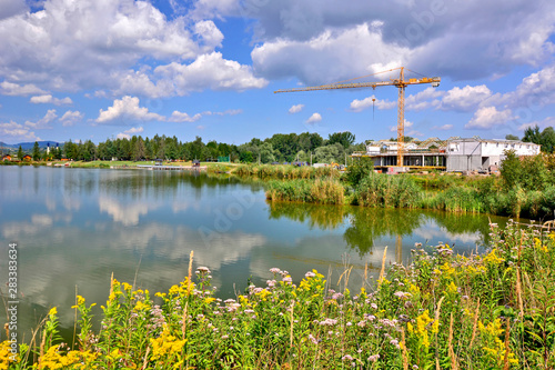 Construction crane and building near a lake for recreation.