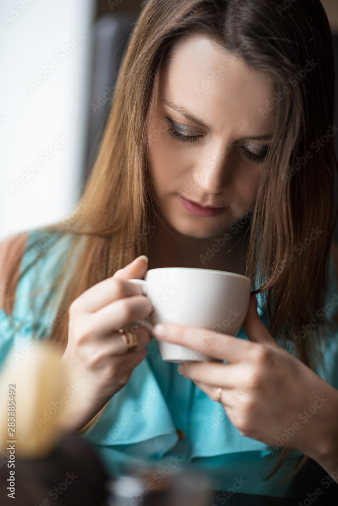 Girl in a cafe is drinking coffee. Portrait of a girl close-up. Girl in a cafe is drinking coffee. Portrait of a girl close-up.
