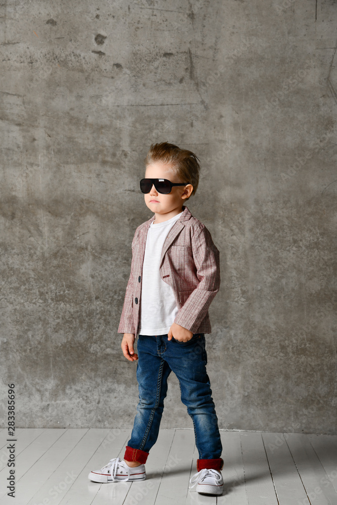 Image of cheerful excited little boy child standing isolated over concrete wall. Image of cheerful excited little boy child standing isolated over concrete wall.