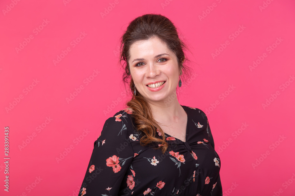 Portrait of a charming brown-eyed young positive woman in posing on a bright pink background Portrait of a charming brown-eyed young positive woman in posing on a bright pink background