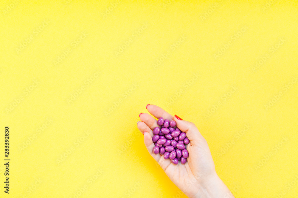 Woman hand holding purple pills handful Woman hand holding purple pills handful