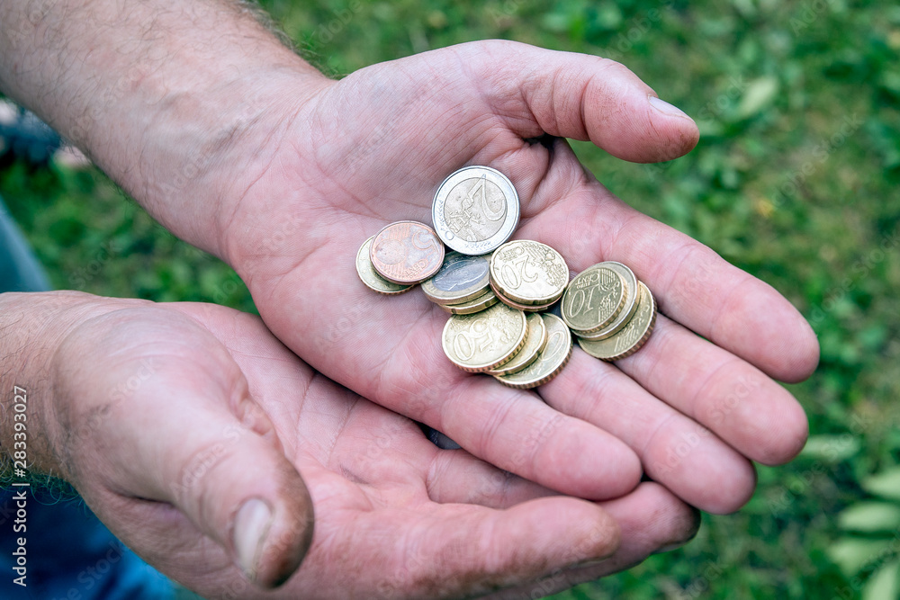 Euro coins in hands of old man; pension and poverty concept Euro coins in hands of old man; pension and poverty concept