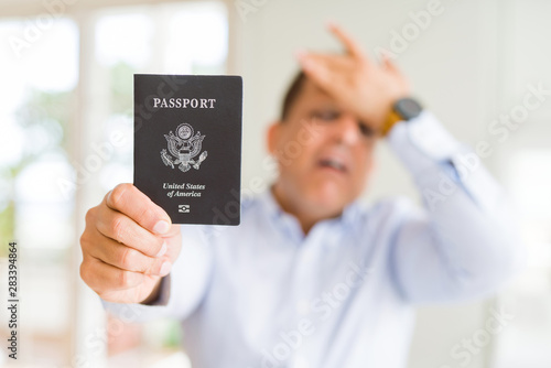 Middle age man holding holding passport of United States stressed with hand on head  shocked with shame and surprise face  angry and frustrated. Fear and upset for mistake.