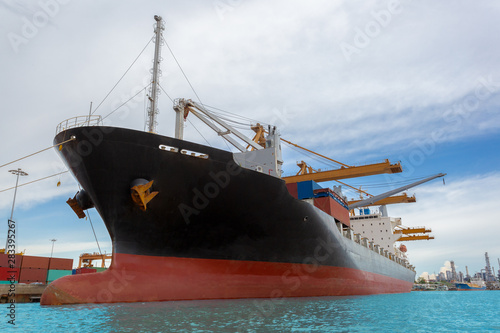 Cargo ships waiting to transfer cargo at the port under bright skies.