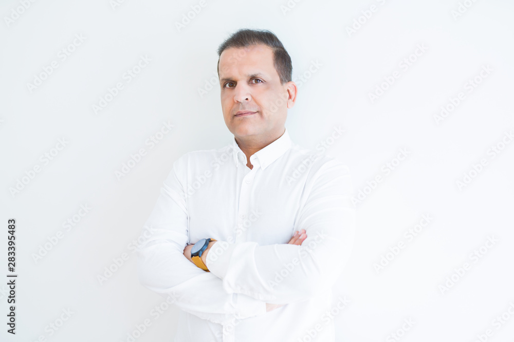 Middle age business man looking natural and relaxed with crossed arms over white wall background Middle age business man looking natural and relaxed with crossed arms over white wall background