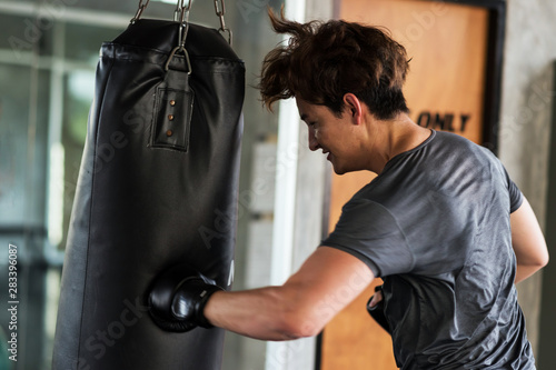man punch big bag at fitness gym © Blanscape