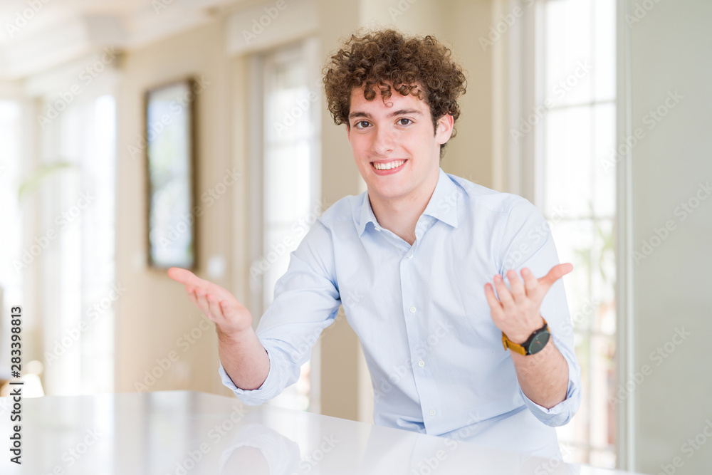 Young business man with curly read head smiling cheerful offering hands giving assistance and acceptance.