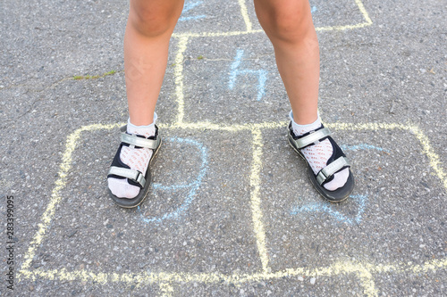 Children's feet close-up on the pavement. View from above. Outdoor games.