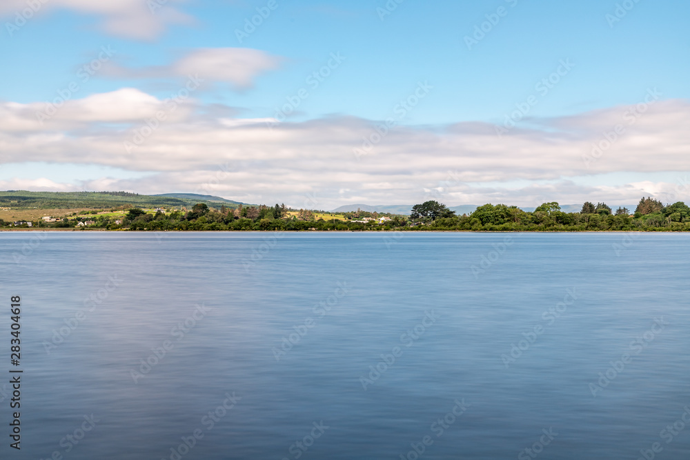 Lough Corrib with forest and farm fields in background