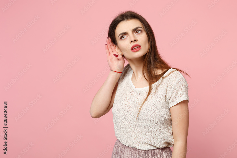 Curious young woman in casual light clothes posing isolated on pink wall background studio portrait. People sincere emotions lifestyle concept. Mock up copy space. Try to hear you with hand near ear. Curious young woman in casual light clothes posing isolated on pink wall background studio portrait. People sincere emotions lifestyle concept. Mock up copy space. Try to hear you with hand near ear.