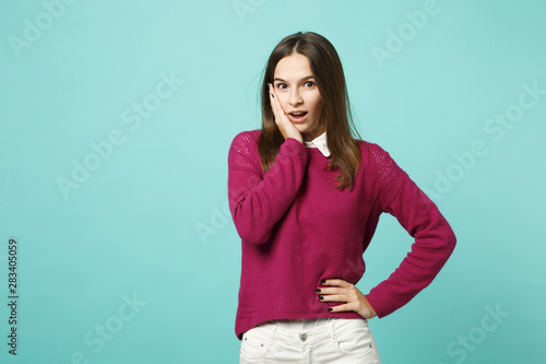 Young brunette woman girl in casual clothes posing isolated on blue green turquoise wall background studio portrait. People sincere emotions lifestyle concept. Mock up copy space. Looking camera shock