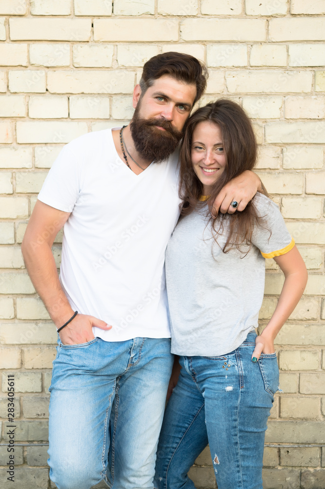 Romantic love. Bearded man hugging pretty woman with love. Erotic love of brutal hipster and sexy woman. Sensual couple in love on brick wall