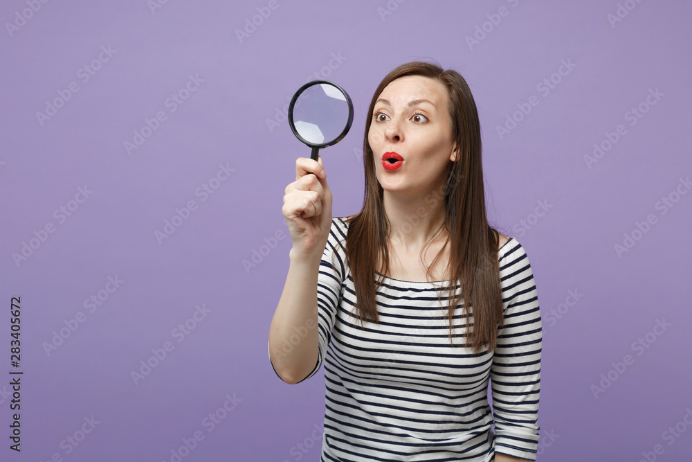 Young brunette woman girl in casual striped clothes posing isolated on violet purple background studio portrait. People sincere emotions lifestyle concept. Mock up copy space. Hold magnifying glass. Young brunette woman girl in casual striped clothes posing isolated on violet purple background studio portrait. People sincere emotions lifestyle concept. Mock up copy space. Hold magnifying glass.