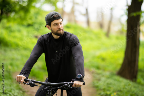 Handsome young man ride bike in the countryside