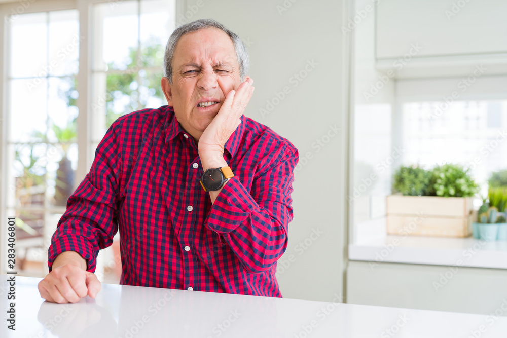 Handsome senior man at home touching mouth with hand with painful expression because of toothache or dental illness on teeth. Dentist concept.