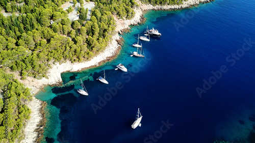 Aerial drone photo of luxury sail boats and yachts docked in turquoise clear water rocky seascape in traditional village of Assos, Cefalonia, Ionian islands, Greece