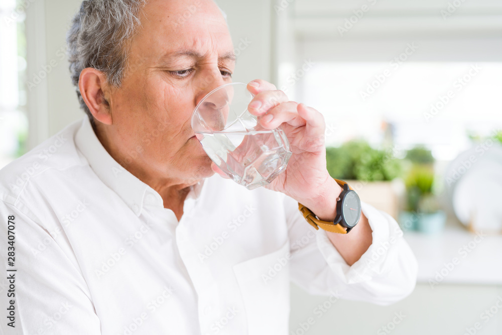 Handsome senior man drinking a fresh glass of water at home Handsome senior man drinking a fresh glass of water at home