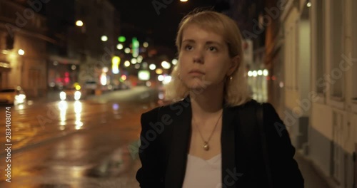 Young business woman in Vienna walking in the street at night. Blonde young woman walks home after a busy day 4k