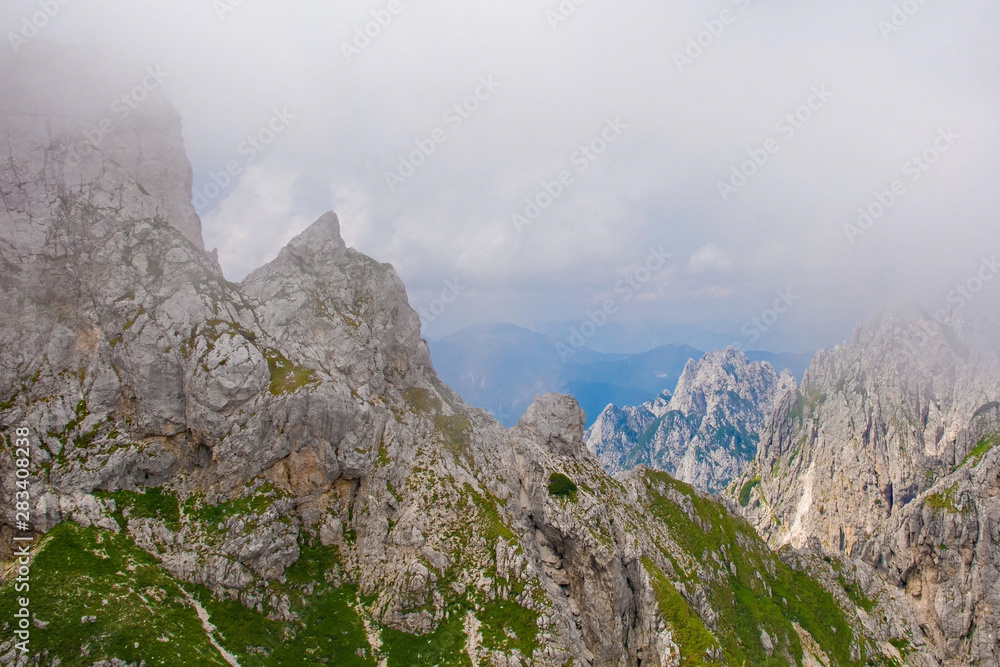 Mangart, also called Mangrt, in low clouds during the summer. Mangart is the third highest mountain in Slovenia and is situated in the Triglav National Park