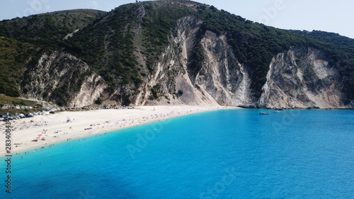 Aerial top view photo of sun beds and umbrellas in popular tropical paradise deep turquoise Mediterranean sandy crowded beach