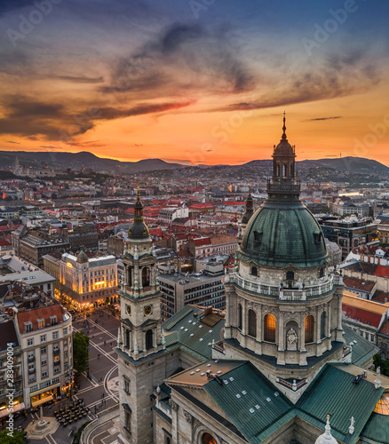 Budapest, Hungary - Aerial drone view of the beautiful St.Stephen's Basilica (Szent Istvan Bazilika) with a golden sunset. Parliament of Hungary and Fisherman's Bastion (Halaszbastya) at background