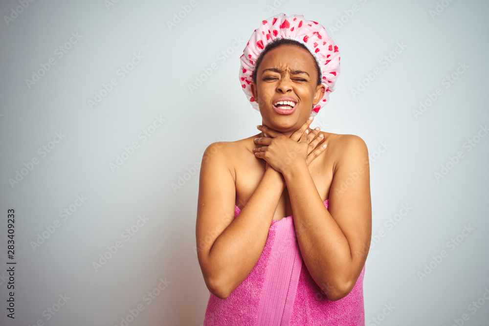 African american woman wearing pink shower towel after bath over isolated background shouting and suffocate because painful strangle. Health problem. Asphyxiate and suicide concept. African american woman wearing pink shower towel after bath over isolated background shouting and suffocate because painful strangle. Health problem. Asphyxiate and suicide concept.