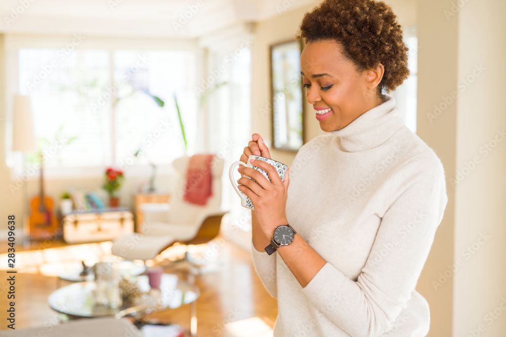 Beautiful young african american woman with afro hair drinking a cup of coffee at home Beautiful young african american woman with afro hair drinking a cup of coffee at home