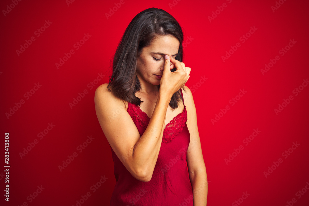 Young beautiful woman wearing sexy lingerie over red isolated background tired rubbing nose and eyes feeling fatigue and headache. Stress and frustration concept. Young beautiful woman wearing sexy lingerie over red isolated background tired rubbing nose and eyes feeling fatigue and headache. Stress and frustration concept.