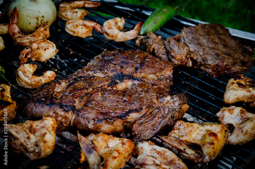 Assorted delicious grilled meat with Shrimp and vegetables over the coals on barbecue Assorted delicious grilled meat with Shrimp and vegetables over the coals on barbecue