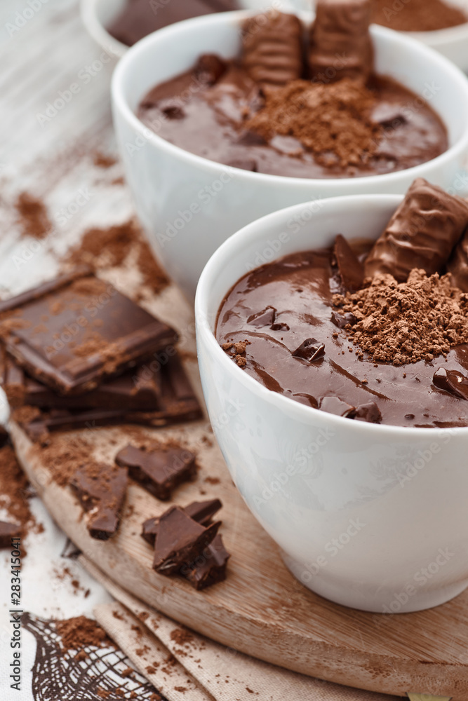 Two mugs of a hot chocolate with chocolate sticks on a wooden board Two mugs of a hot chocolate with chocolate sticks on a wooden board