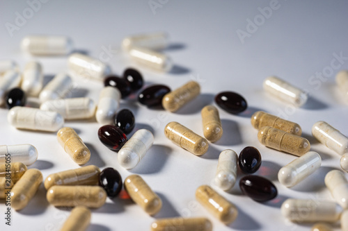 Piles of pills and capsule on white background. Selective focus