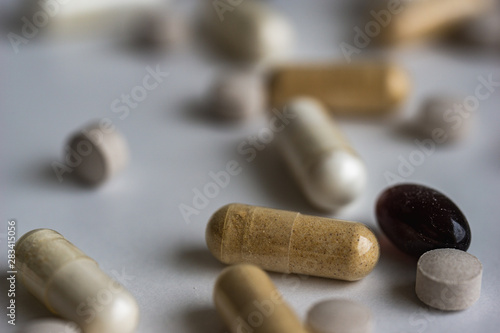 Piles of pills and capsule on white background. Selective focus