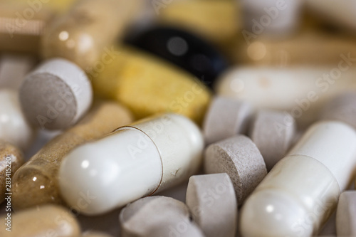 Piles of pills and capsule on white background. Selective focus