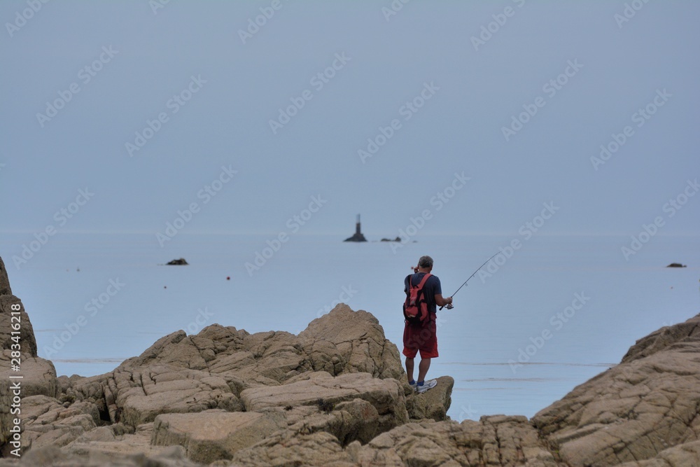 Pêcheur sur un rocher à Perros-Guirec en Bretagne