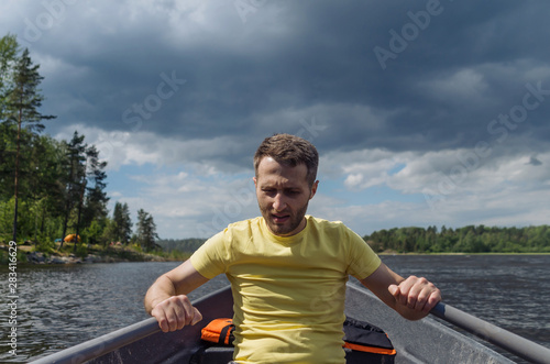 A tired man paddling against the wind on a lake during the storm