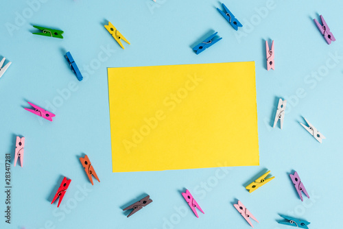 Colored clothespin rectangle shaped reminder paper light blue background