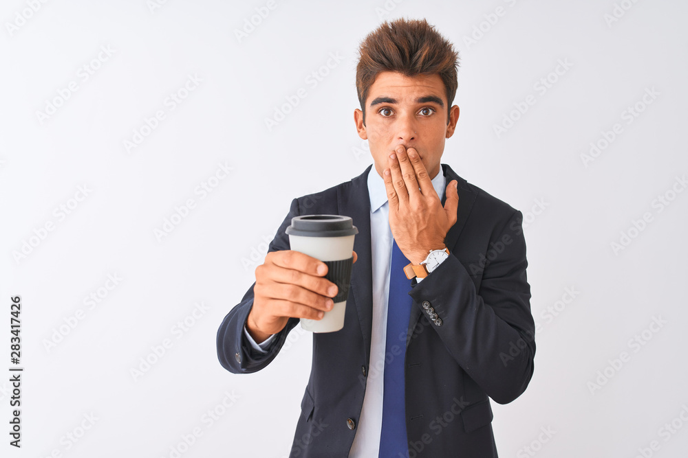 Young handsome businessman wearing suit holding coffee over isolated white background cover mouth with hand shocked with shame for mistake, expression of fear, scared in silence, secret concept Young handsome businessman wearing suit holding coffee over isolated white background cover mouth with hand shocked with shame for mistake, expression of fear, scared in silence, secret concept