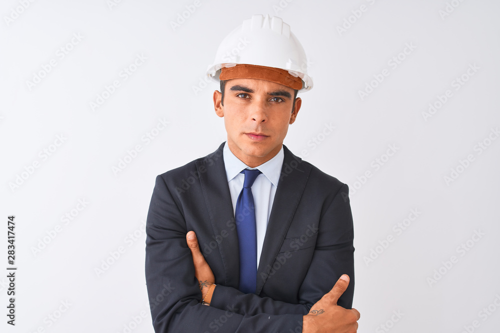 Young handsome architect man wearing suit and helmet over isolated white background skeptic and nervous, disapproving expression on face with crossed arms. Negative person.